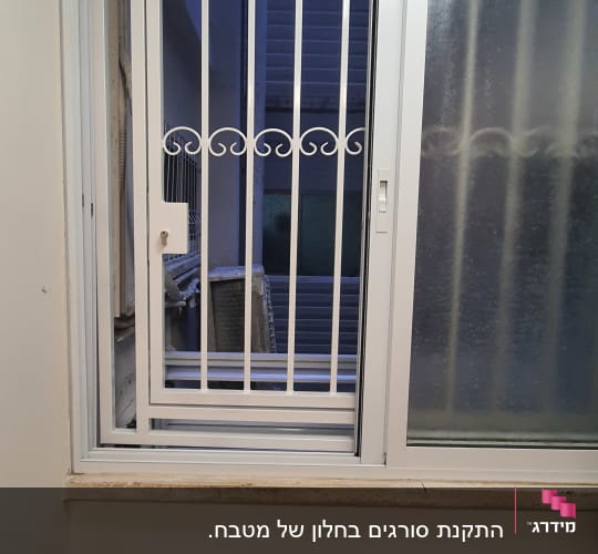 חלון עם סורגים לבנים ודלת הזזה מזכוכית